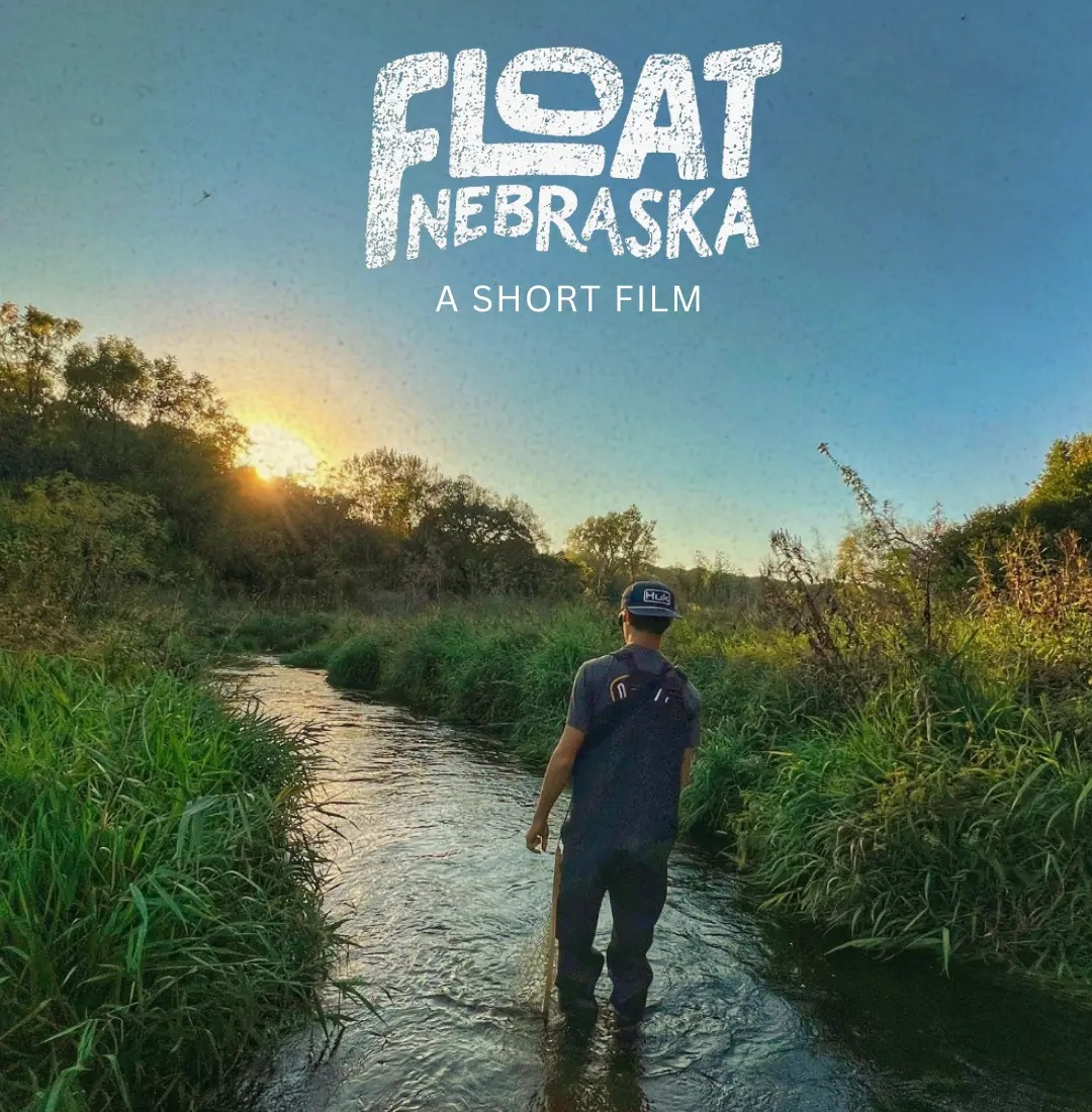 Float Nebraska, a short film: the title set over a man wading knee-deep through a grass-lined Nebraska creek at sunrise